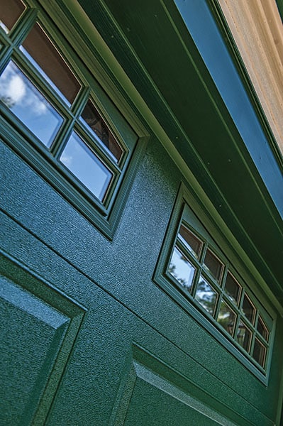 Close up of green garage door with windows